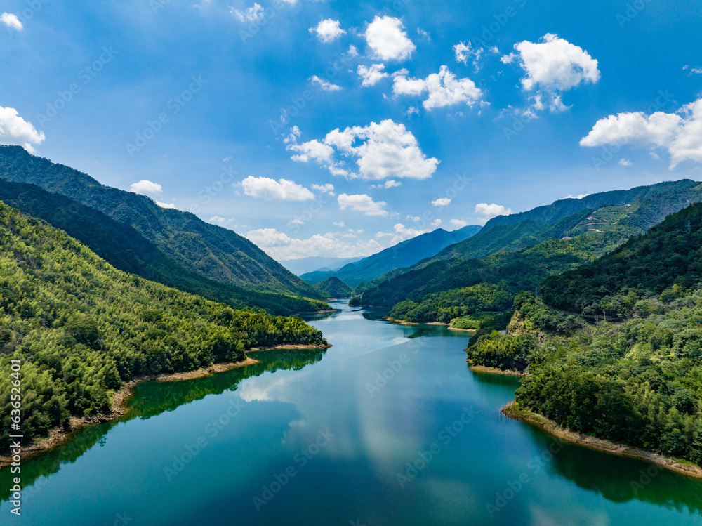 Aerial photography of a large reservoir with blue sky and white clouds and mountains