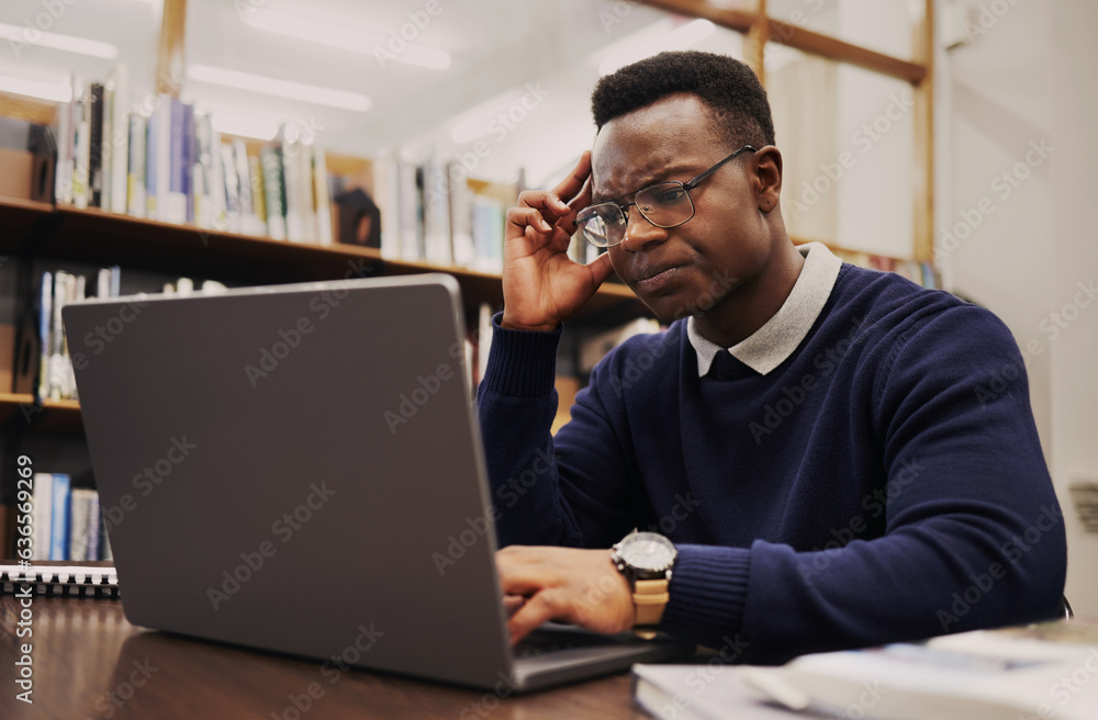 Man, student and thinking on laptop in library for studying, university research or headache and str