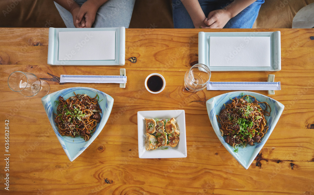 Chinese food, sushi and noodles on a table in a restaurant from above during a date in an asian eate