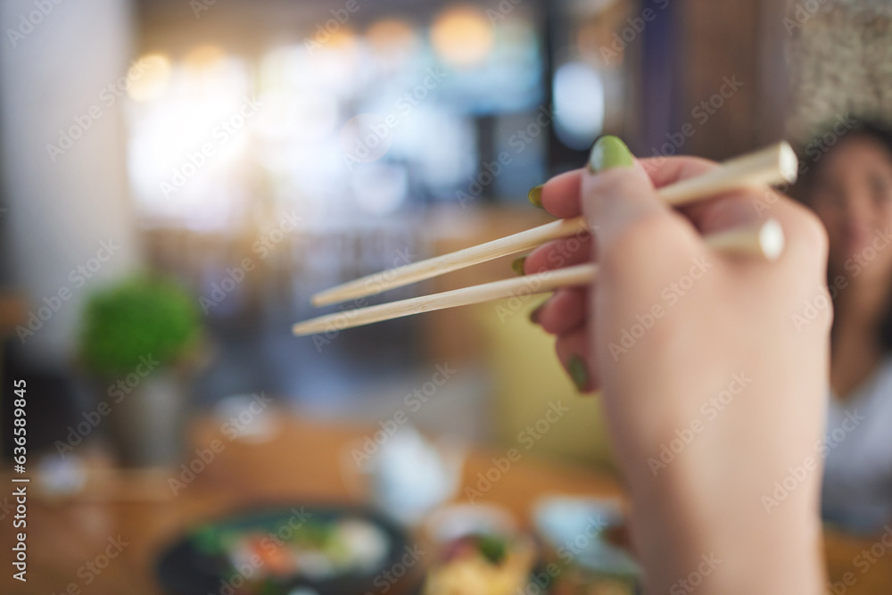 Tradition, bamboo chopsticks and hand of a person eating Japanese food at a restaurant for nutrition