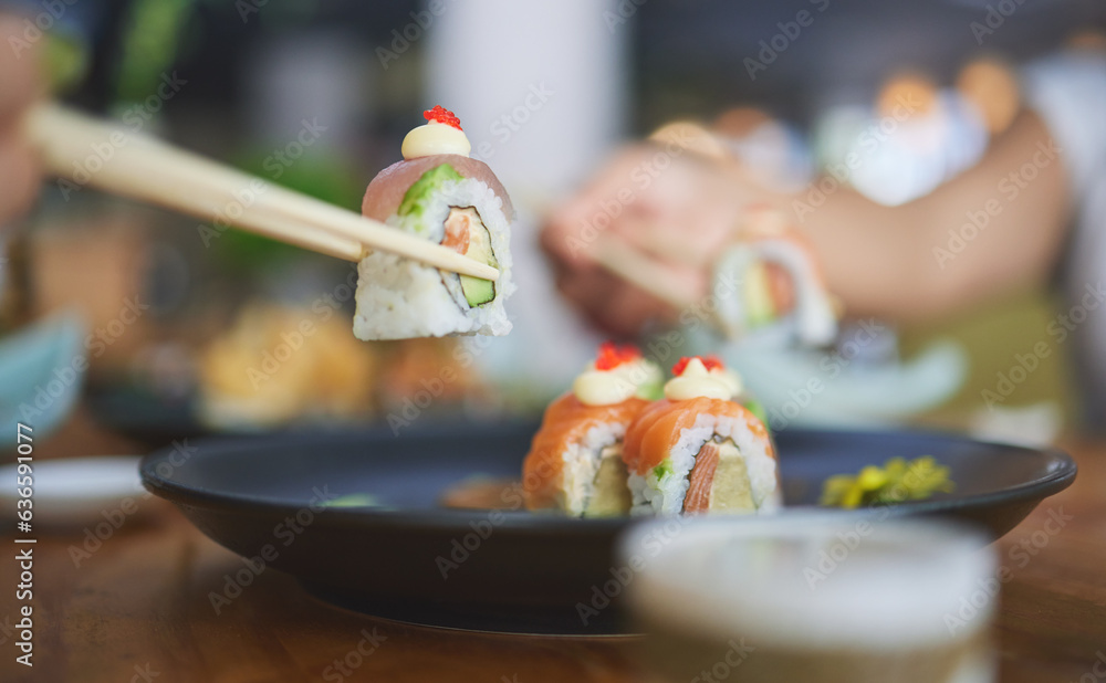 Chopsticks, food and eating sushi at a restaurant for nutrition at table. Closeup of hungry people w