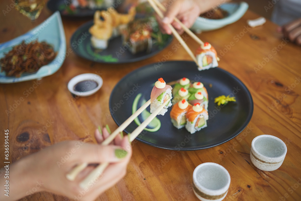 Sushi, hands and eating food with chopsticks at restaurant for nutrition at table. Closeup of people