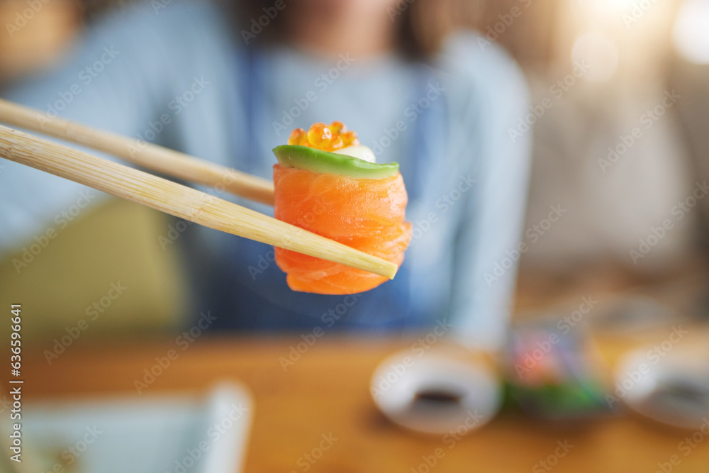 Sushi, eating food and hand with chopsticks at restaurant for nutrition and health. Closeup of a per