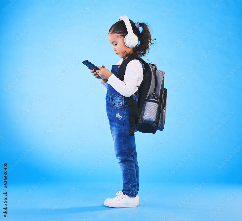 Headphones, backpack and child on blue background with phone ready for school, learning and educatio