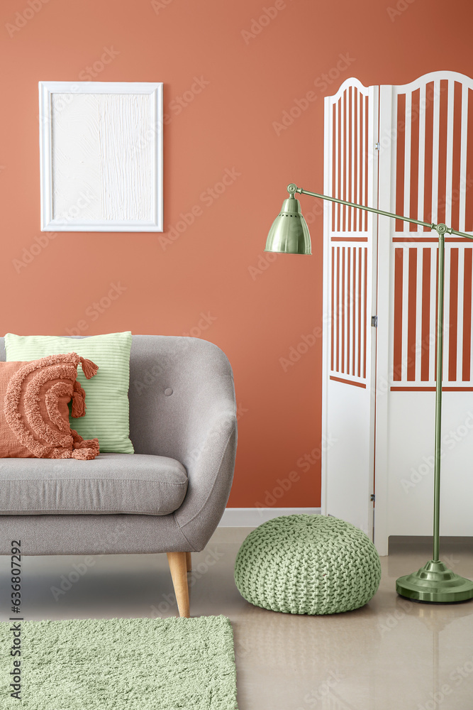 Interior of modern living room with folding screen, standard lamp and grey sofa