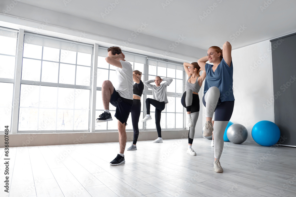 Group of sporty young people training in gym