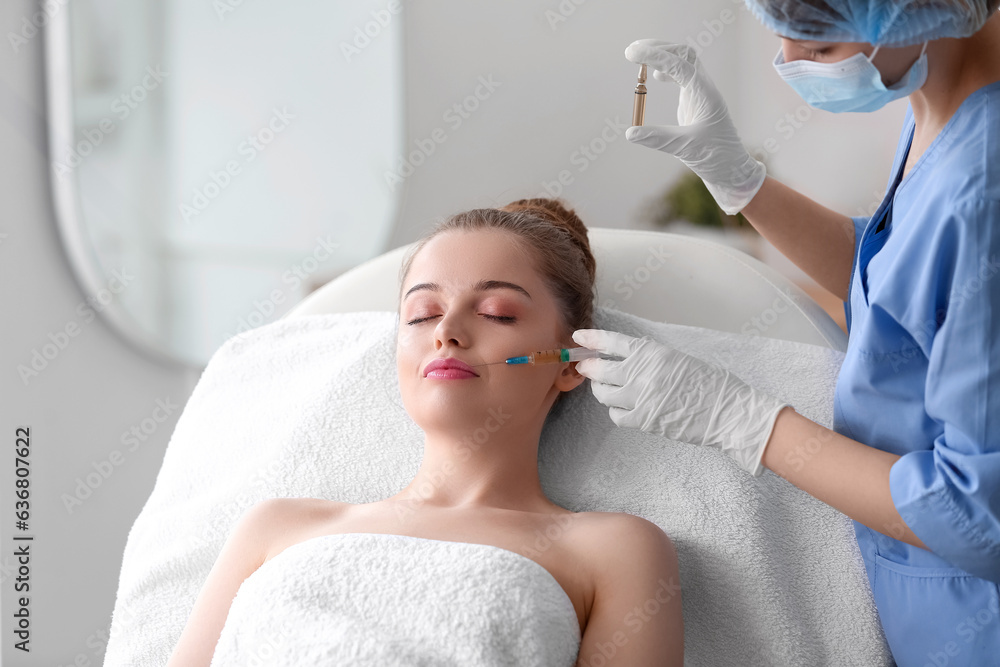 Young woman receiving injection in beauty salon. Skin care concept