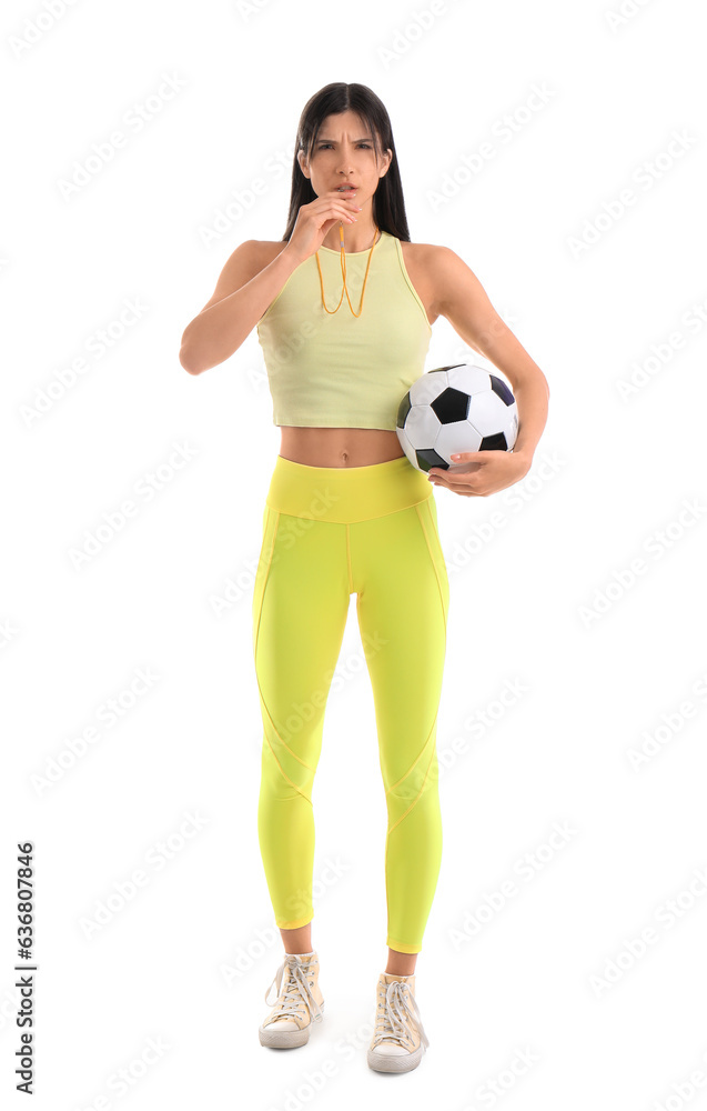 Sporty female coach with soccer ball and whistle on white background