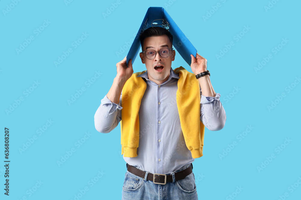 Stressed businessman with folder on blue background. Deadline concept