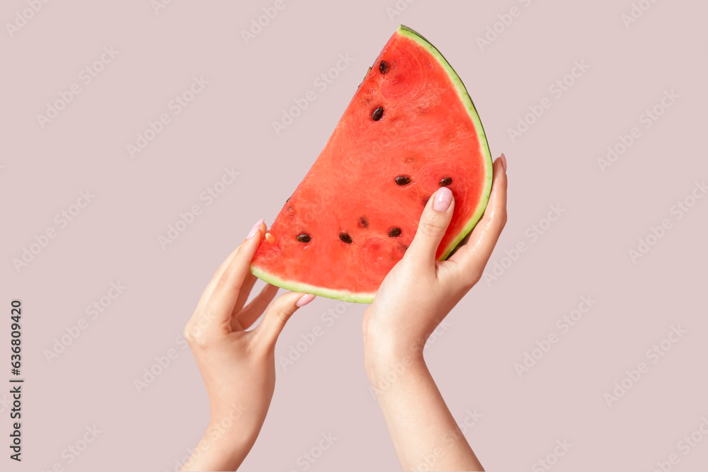 Female hands with piece of ripe watermelon on beige background