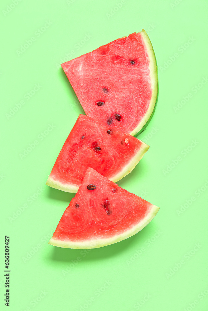 Pieces of ripe watermelon on green background