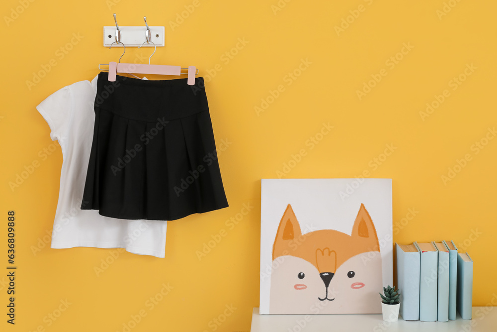 Stylish school uniform hanging in room