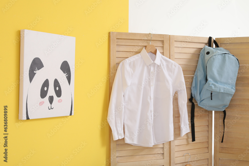 Stylish school uniform hanging in room