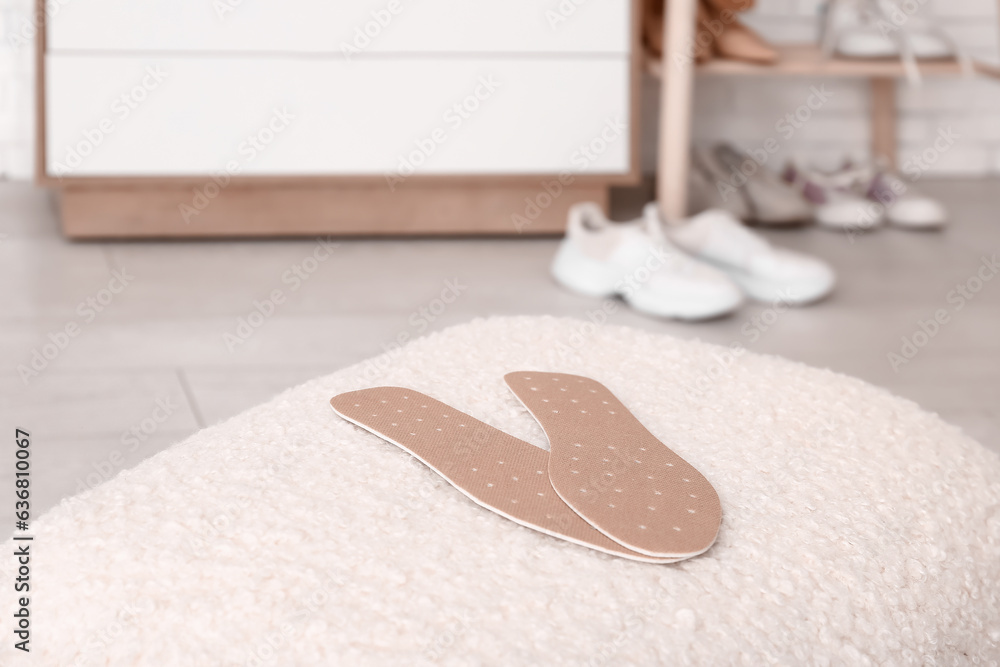 Orthopedic insoles on stool in room, closeup