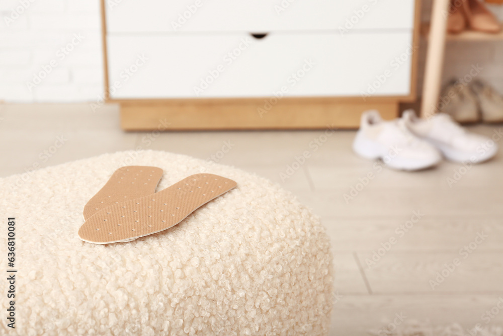 Orthopedic insoles on stool in room, closeup