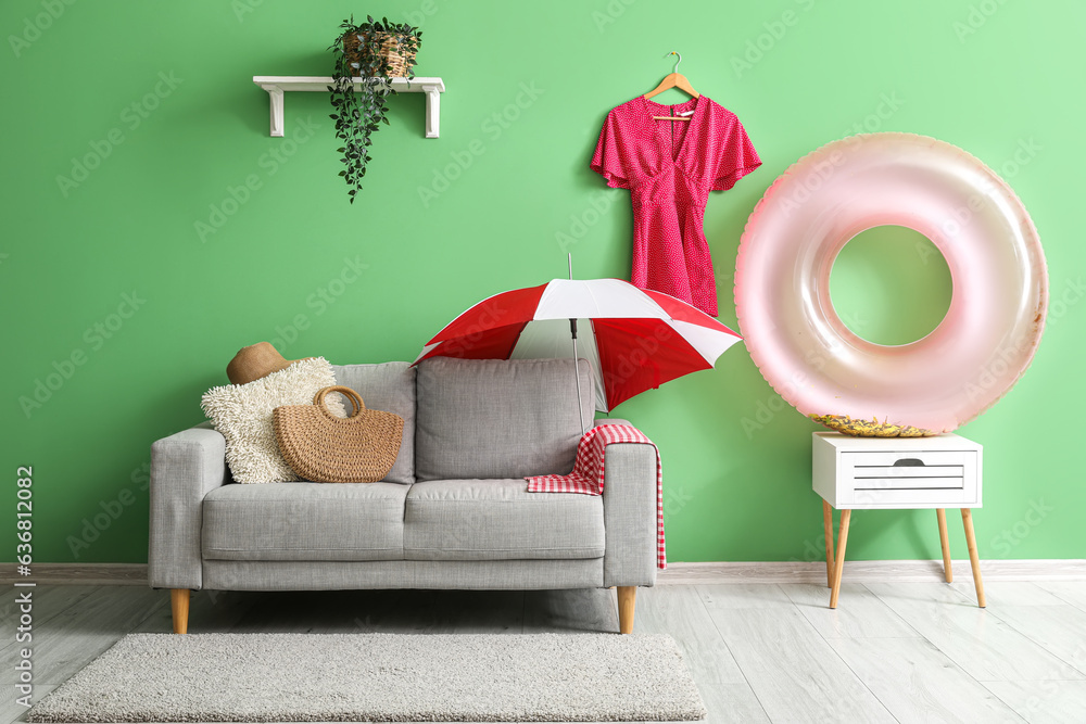 Interior of stylish living room with beach accessories near green wall