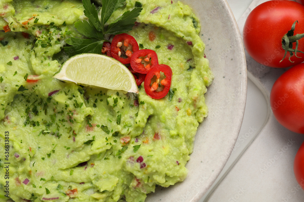 Delicious guacamole and ingredients on white table, flat lay