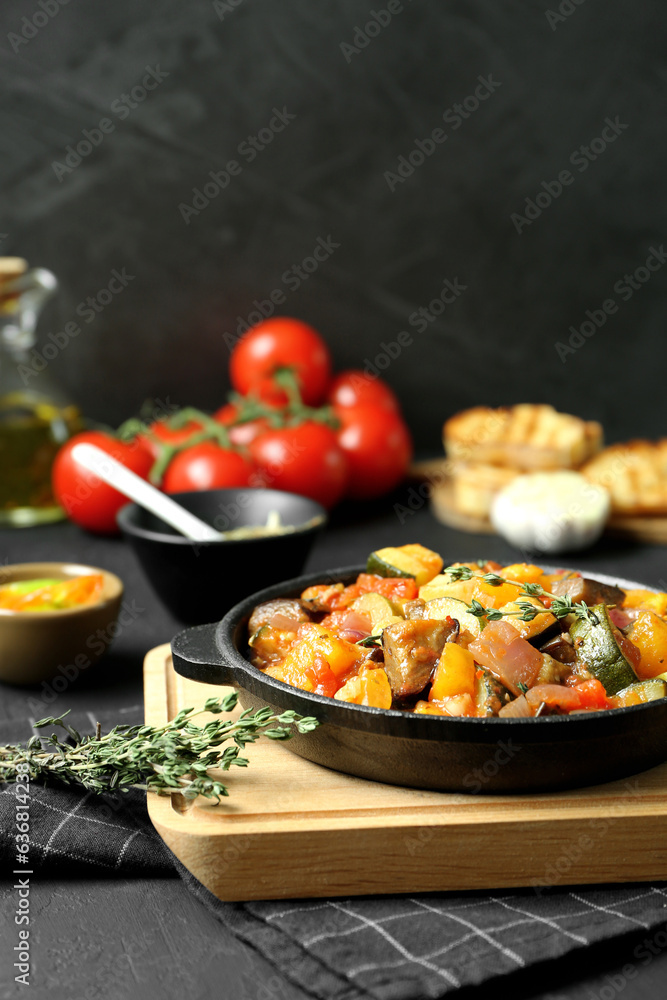 Dish with tasty ratatouille on black table