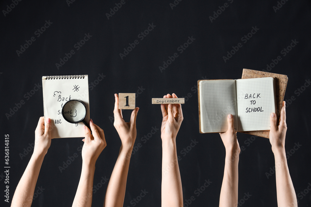 Female hands holding calendar, magnifier and notebooks with text BACK TO SCHOOL on black background