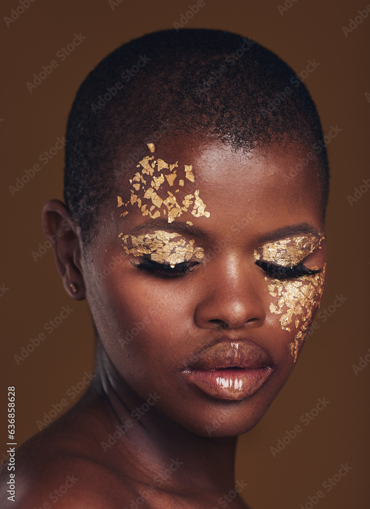 Gold flakes, beauty and black woman with face closeup with makeup and cosmetics in studio. Brown bac