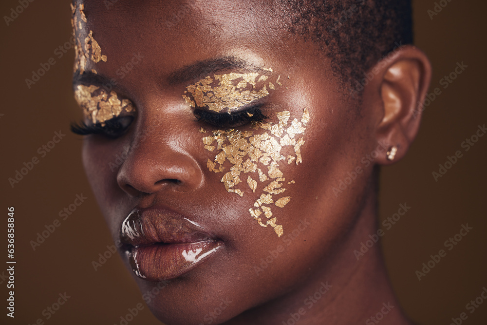 Gold, creative and black woman with makeup for beauty aesthetics isolated in a studio brown backgrou