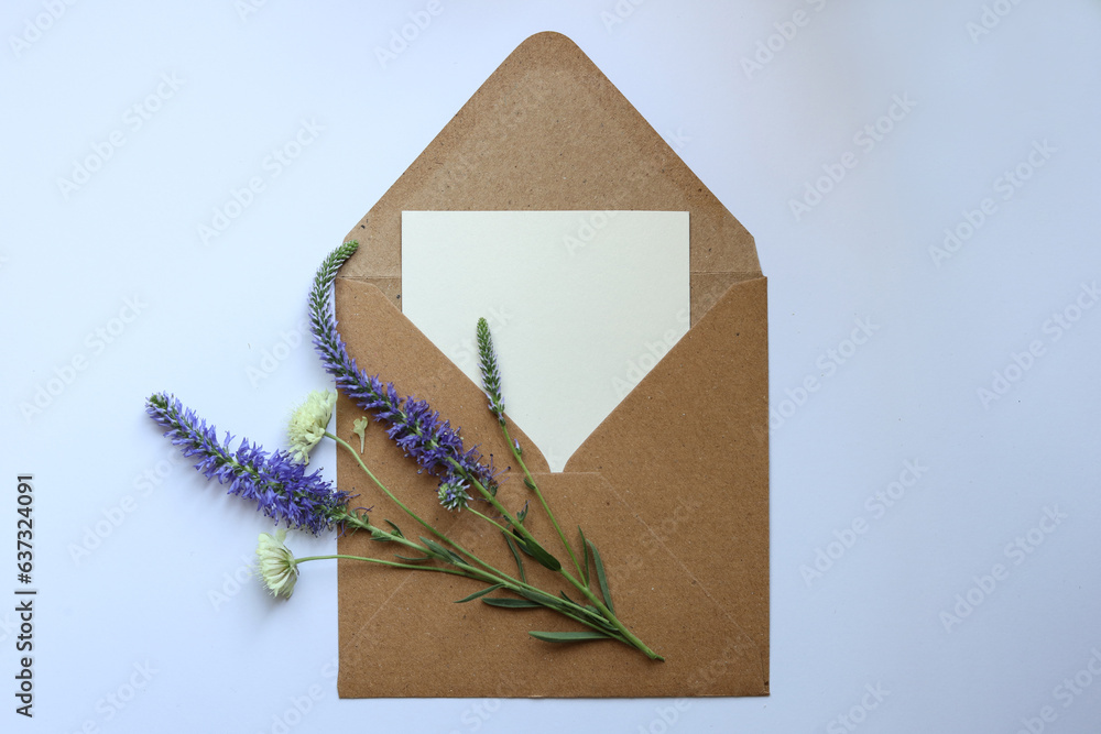 a blank message card in a brown envelope with wild flowers on top