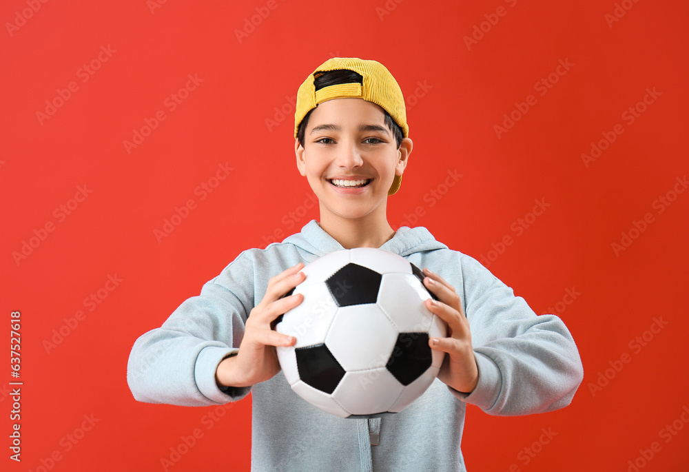 Little boy with soccer ball on red background