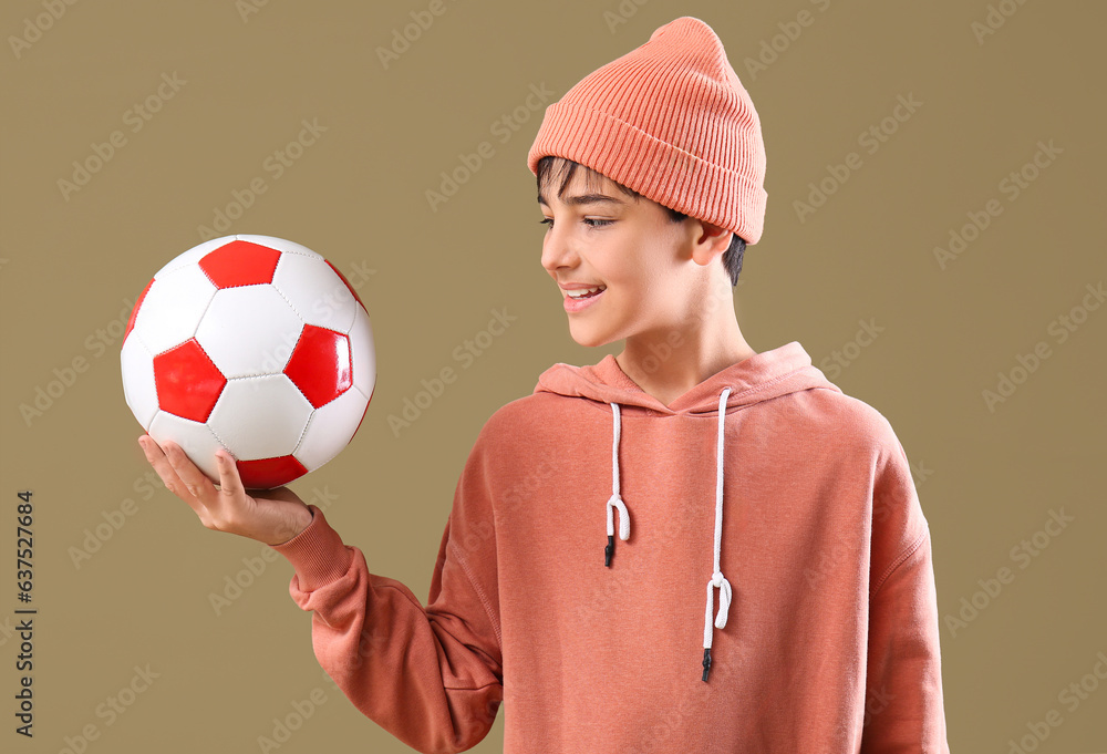 Little boy with soccer ball on color background