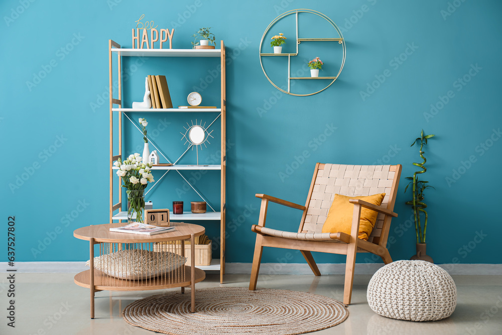 Interior of room with shelving unit and stylish holder for books near blue wall