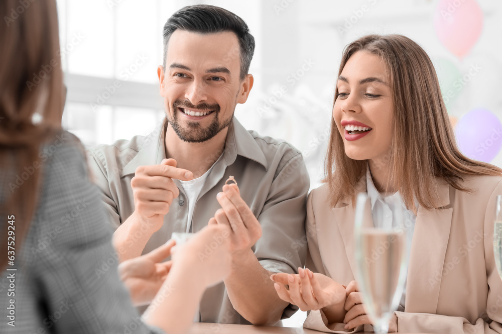 Young couple choosing ring for their wedding in office