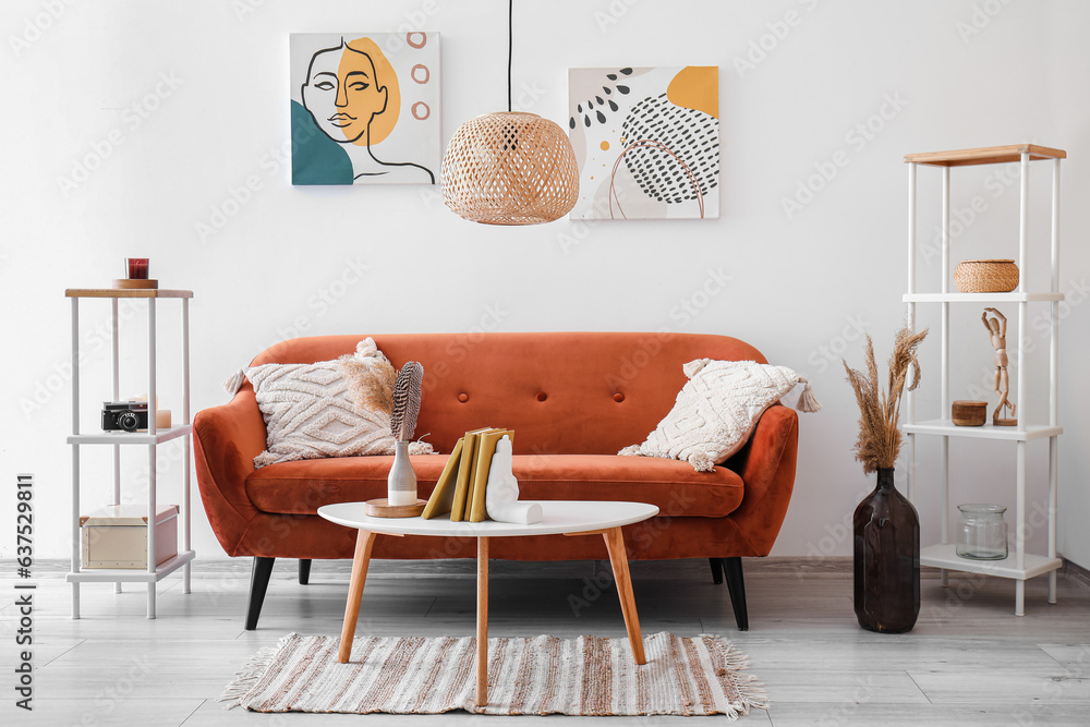 Interior of modern room with sofa and stylish holder for books on table