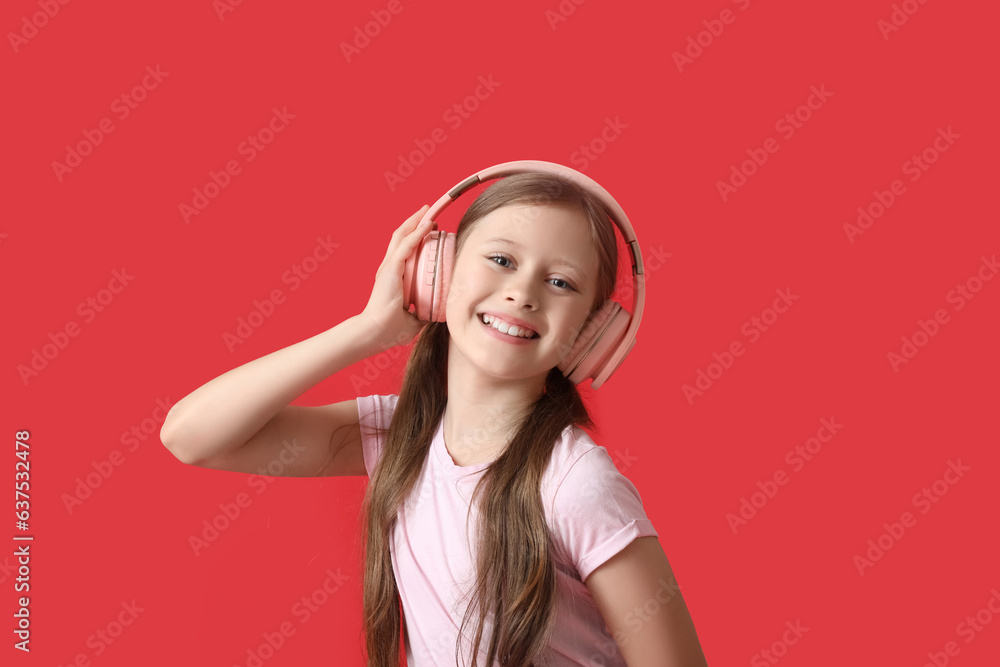 Little girl in headphones on red background