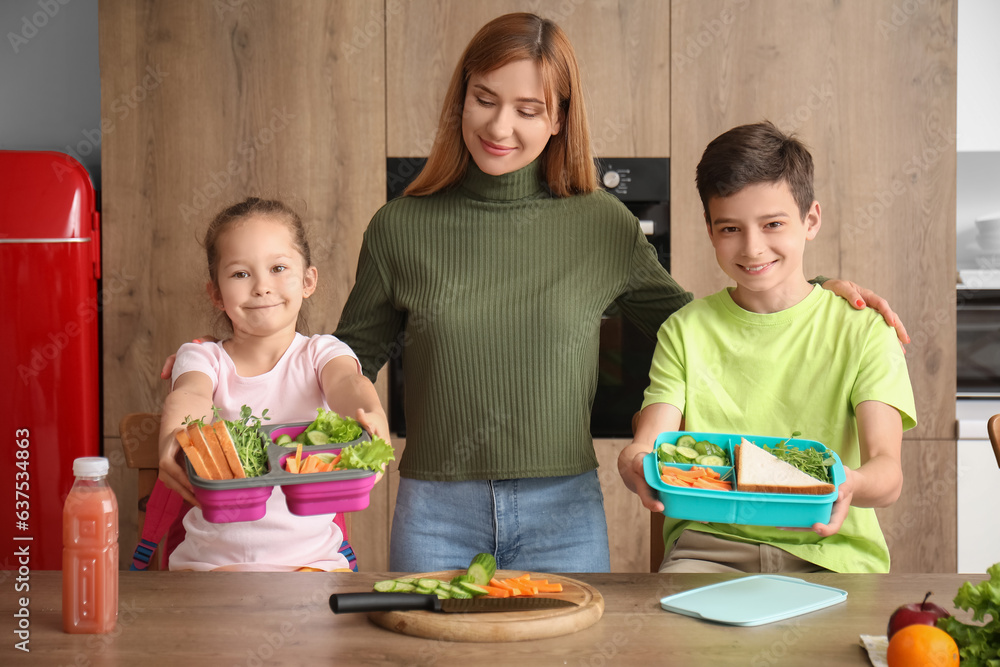 Mother and her little children with school lunch boxes in kitchen