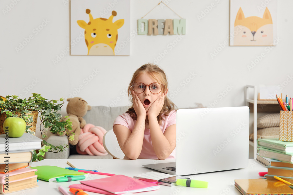 Shocked little girl doing lessons at home