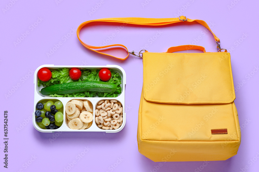 Bag and lunchbox with tasty food on lilac background