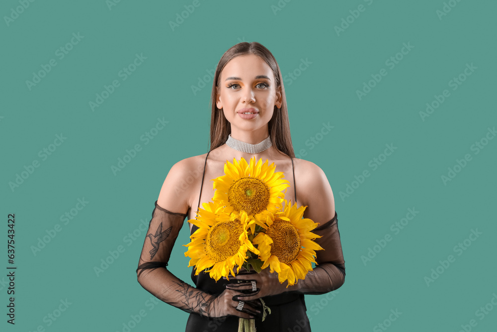 Elegant happy young woman with bouquet of beautiful sunflowers on green background