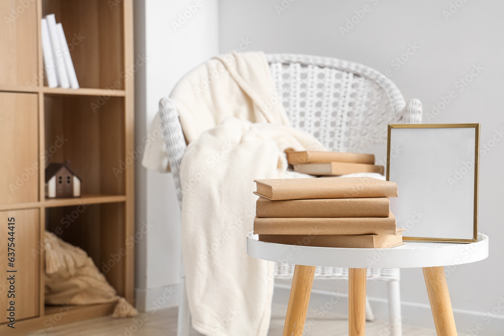 Stack of books with frame on table in living room