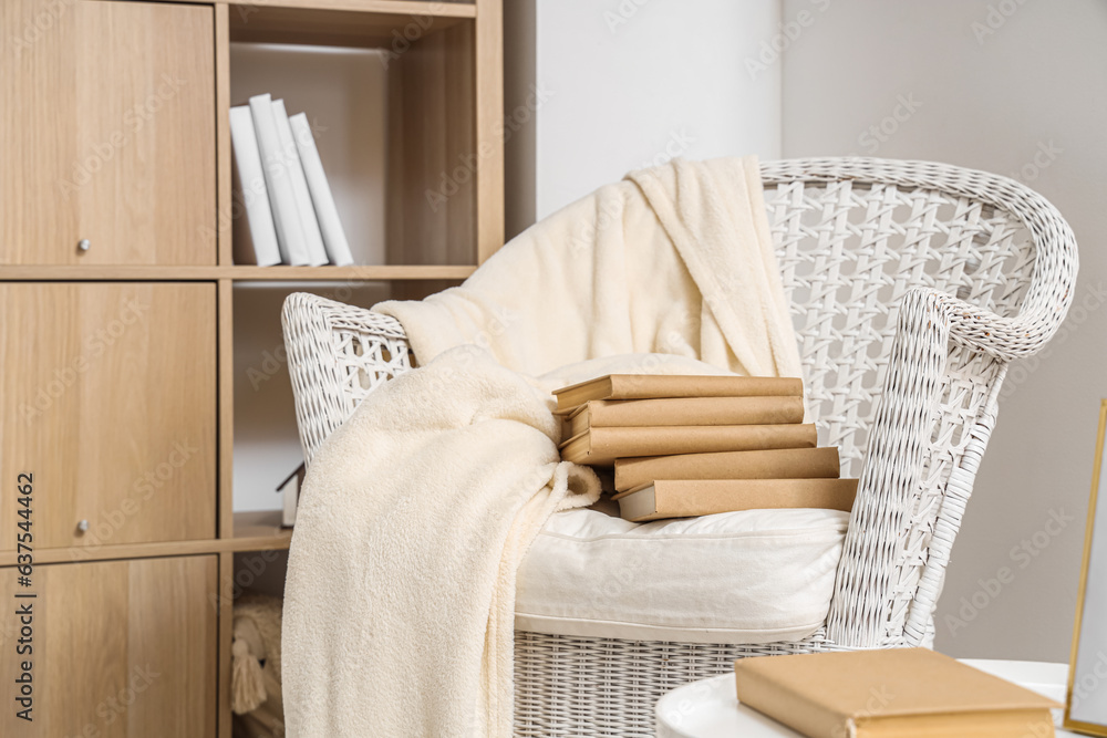 Comfortable armchair with books in living room