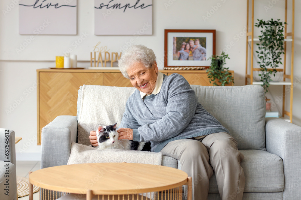 Senior woman with cute cat resting at home