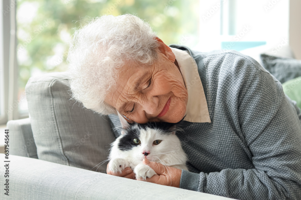 Senior woman with cute cat resting at home