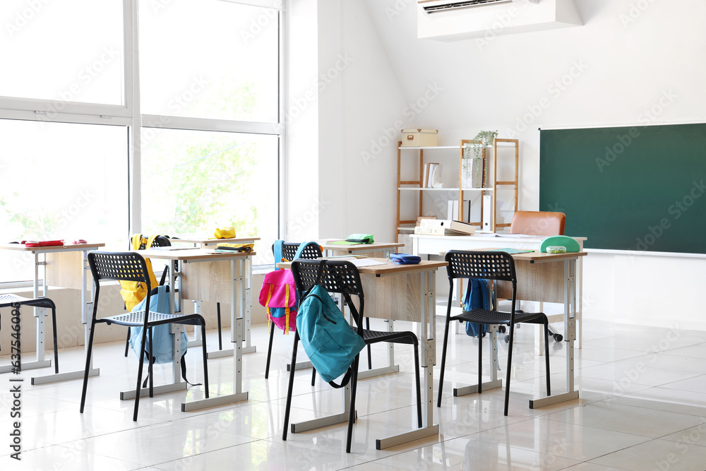 Interior of modern classroom with desks and chairs at school