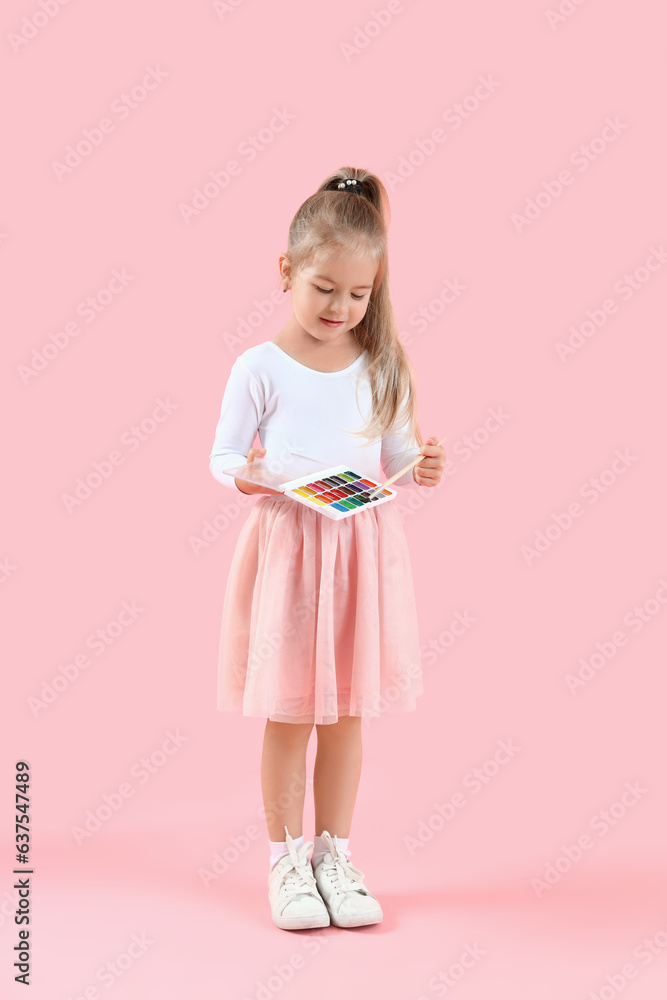 Cute little girl with paints and brush on pink background