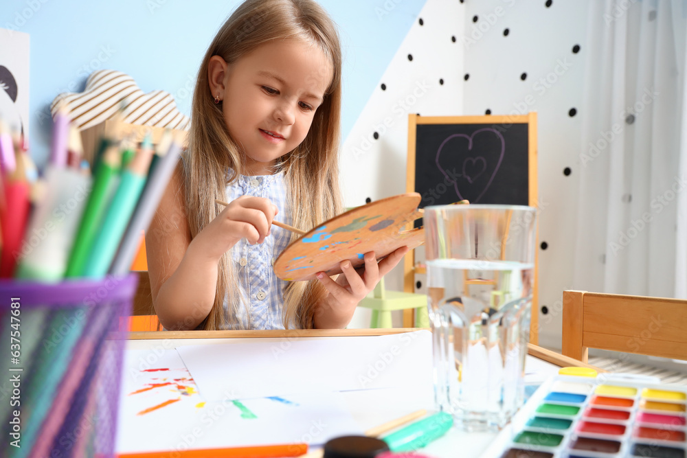 Cute little girl with paint palette at home