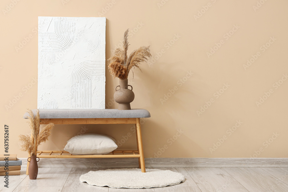 Interior of stylish room with soft bench near beige wall