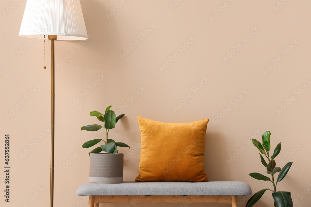 Interior of stylish room with soft bench near beige wall