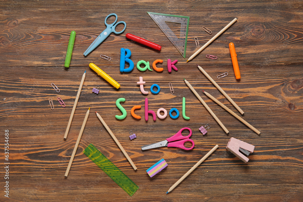 Text BACK TO SCHOOL and stationery on wooden background