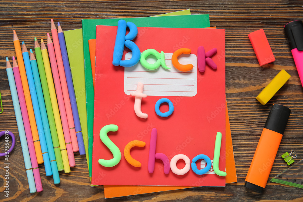 Text BACK TO SCHOOL and stationery on wooden background