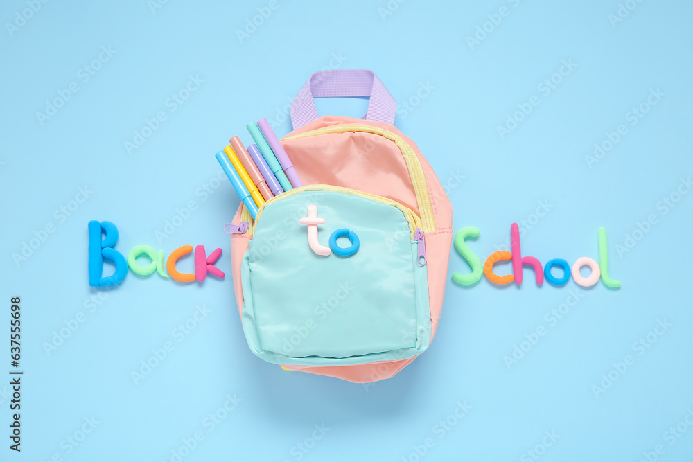 Text BACK TO SCHOOL, backpack and markers on light blue background