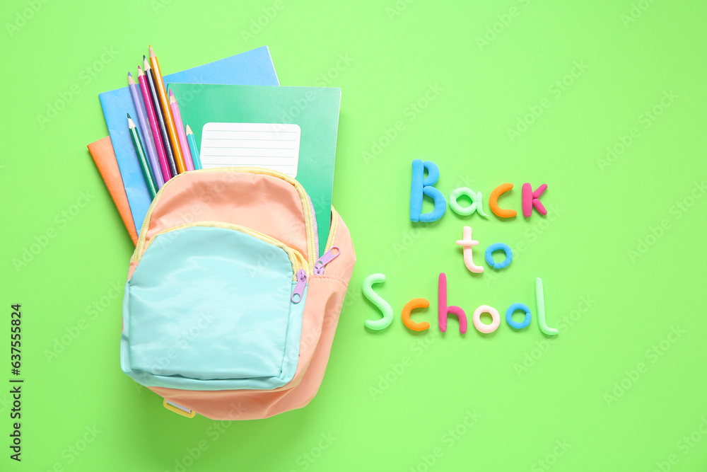 Text BACK TO SCHOOL, backpack and stationery on green background