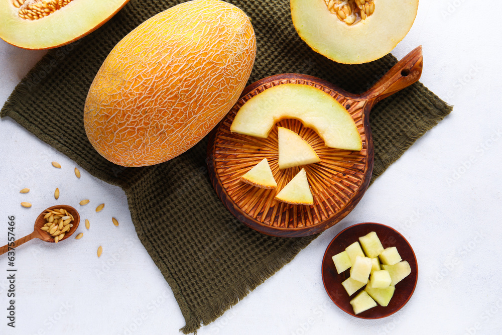 Wooden board and bowl with sweet cut melon on white background